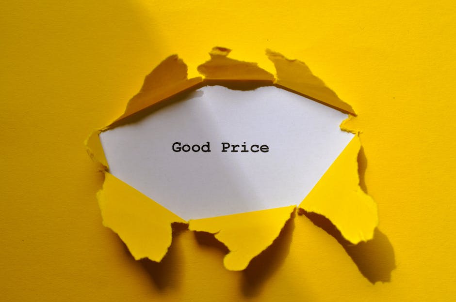 A close-up of a torn yellow paper surface revealing a white interior, with jagged edges and torn pieces around the opening, through which a piece of white paper with the typed words 'Good Price' is vi